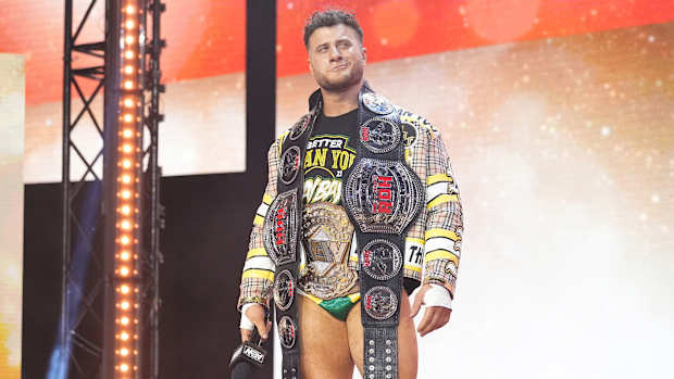 MJF poses with the AEW world championship and Ring of Honor tag team championship belts
